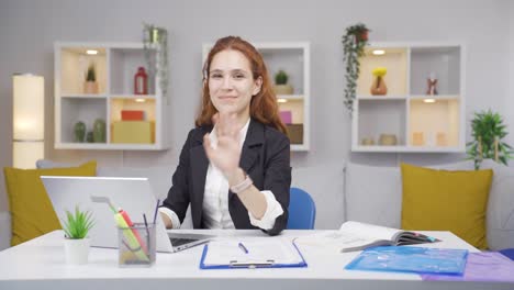 Home-office-worker-woman-waving-at-camera.